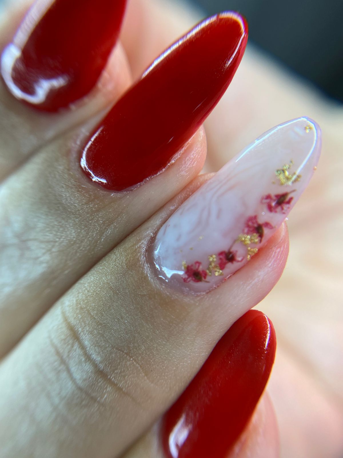 Unhas vermelhas com nail art de flores delicadas feita no Millano