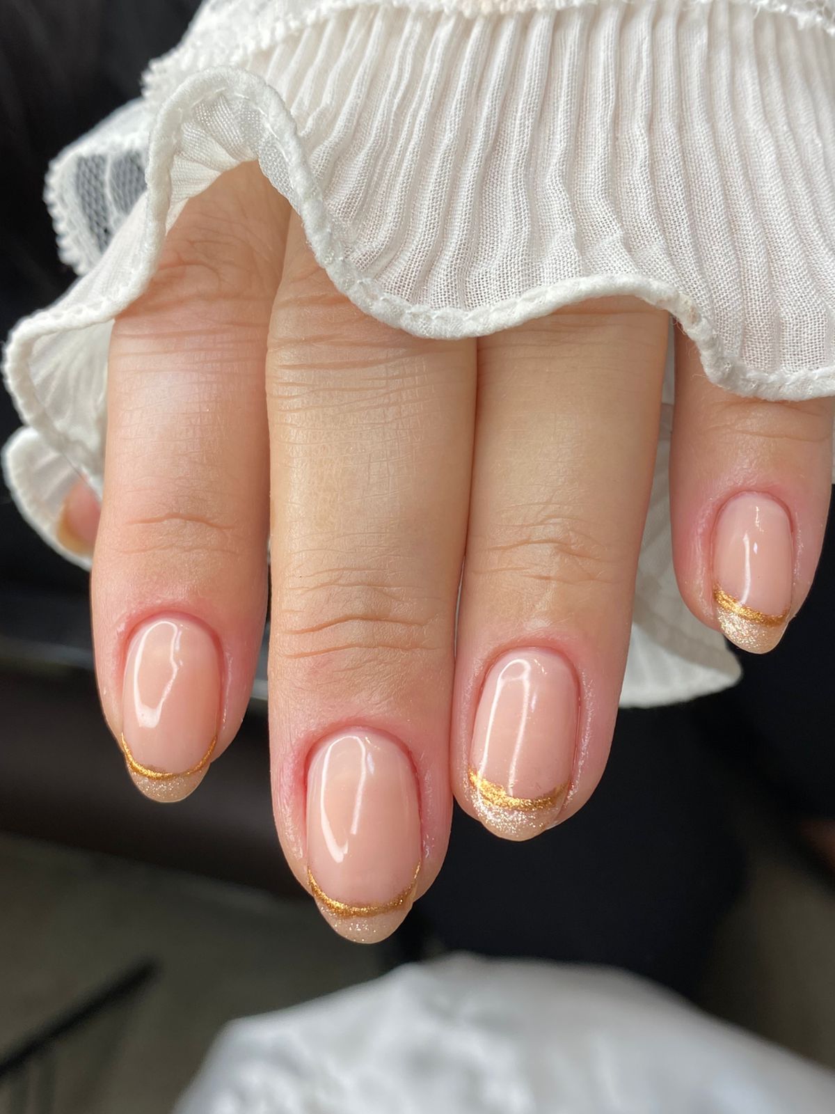 Esmaltação nude impecável com francesinha dourada feita no Millano